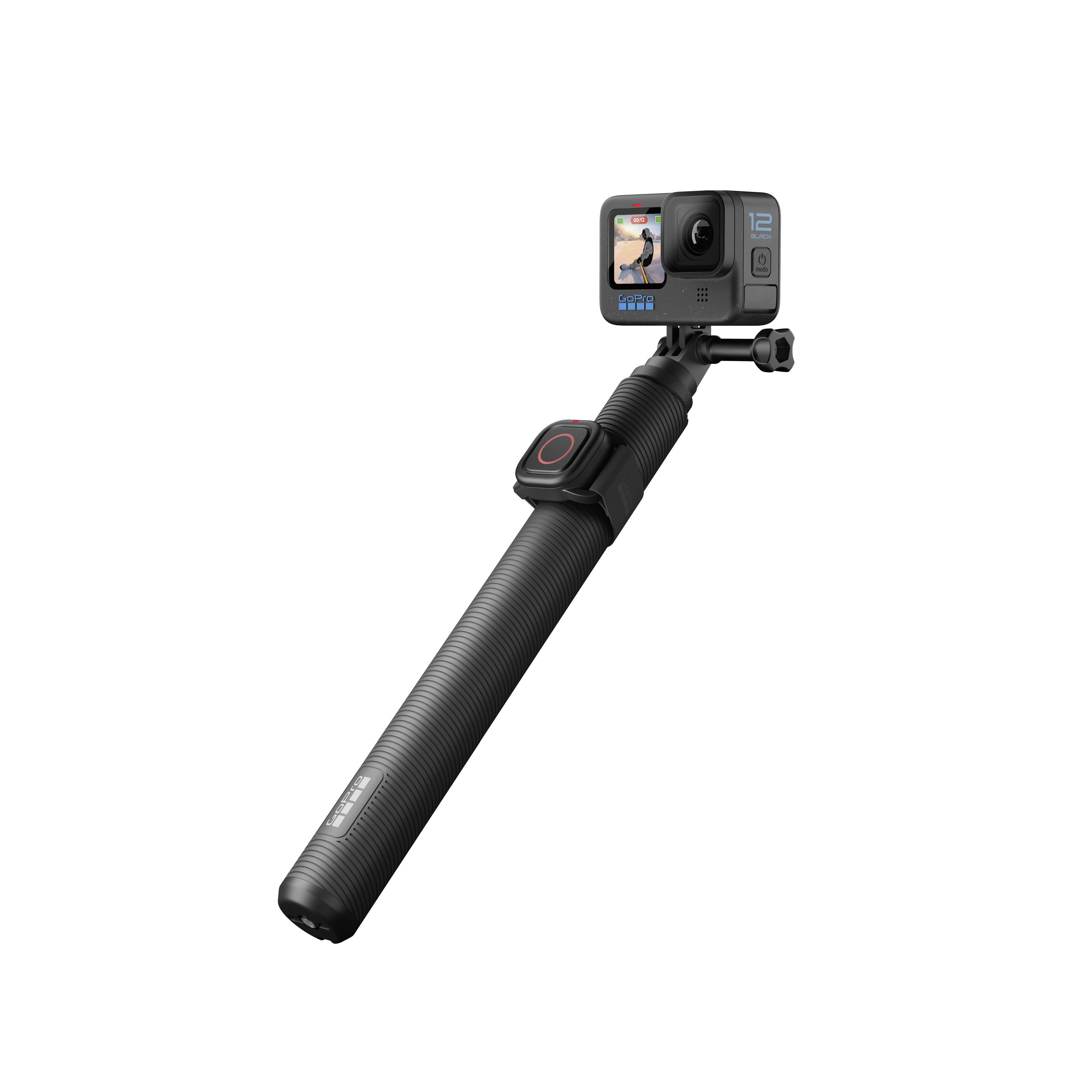 An action camera with a mounting grip and a small screen displaying a recording.