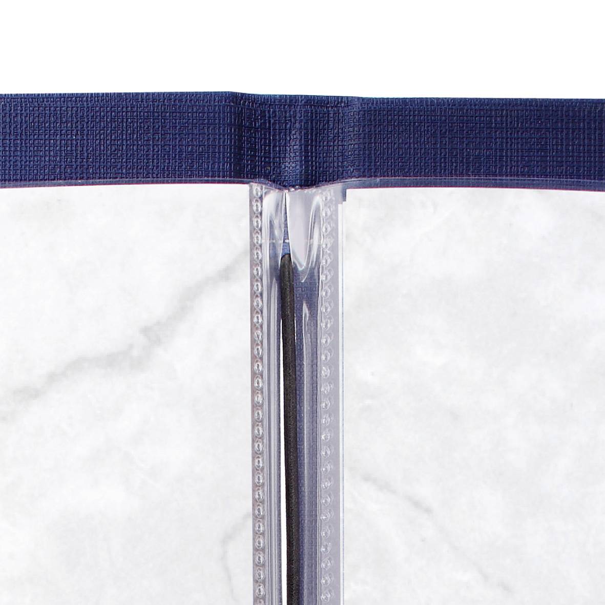 A book with light grey pages and a dark blue cover lies flat on a white marble surface.