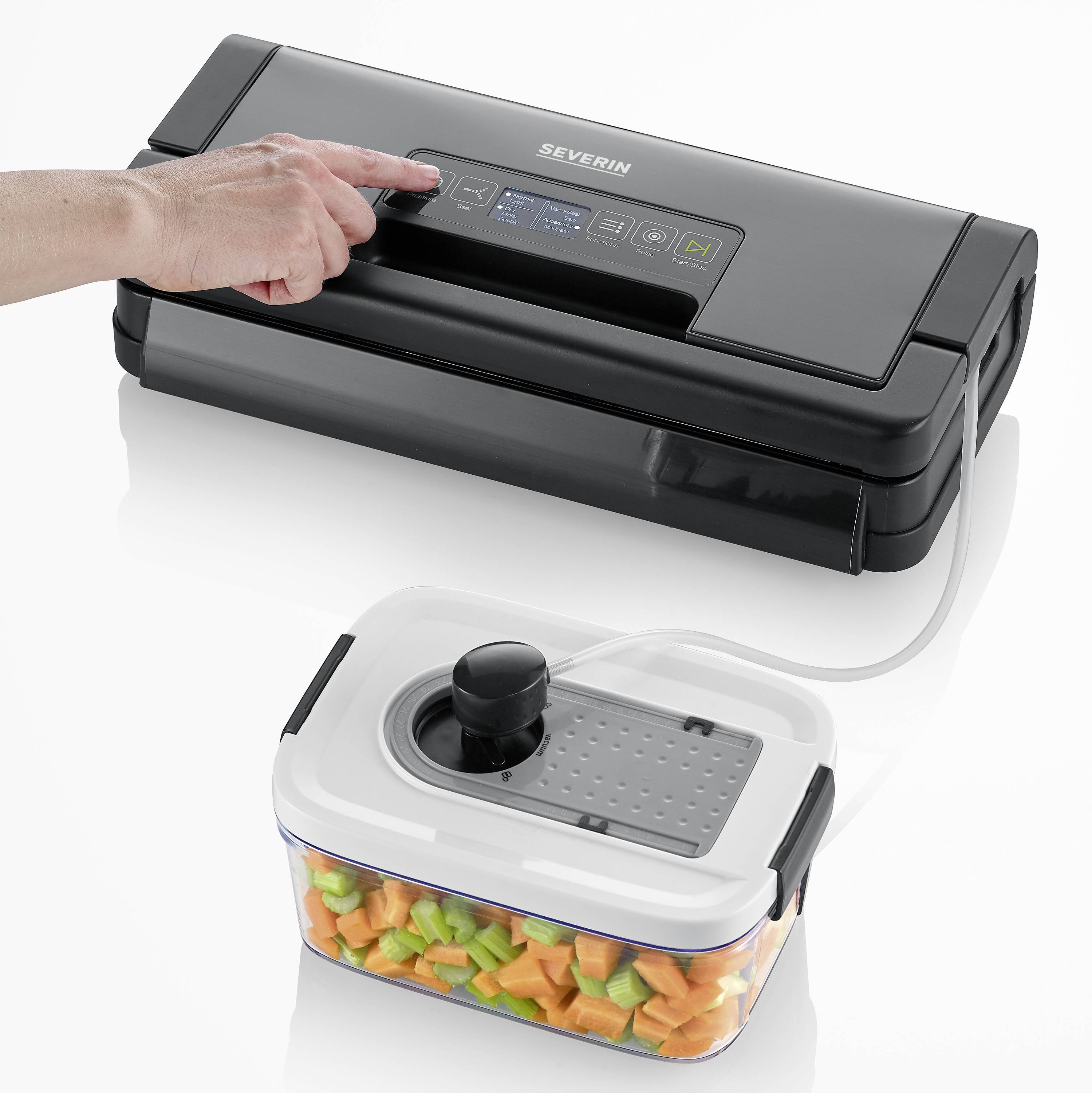 A person is operating a black vacuum sealing device with a container full of chopped vegetables in front of them.