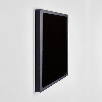 A black, wall-mounted screen displays nothing. The device is photographed from a side perspective.
