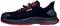 A black safety shoe with red details, a flat profile and brand logo on the side. The shoe has a thick sole.