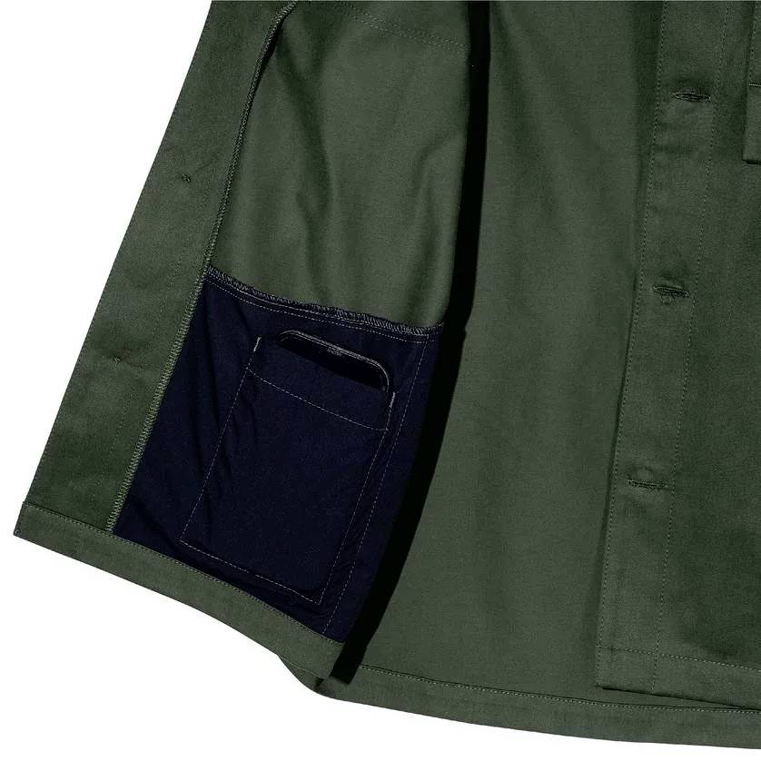 Green shirt with open pocket lining in navy blue. The pocket is visibly stitched and provides space for small items.