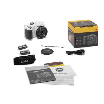 A digital camera with accessories: batteries, lens cap, shoulder strap, USB cable and instruction manual in front of packaging.
