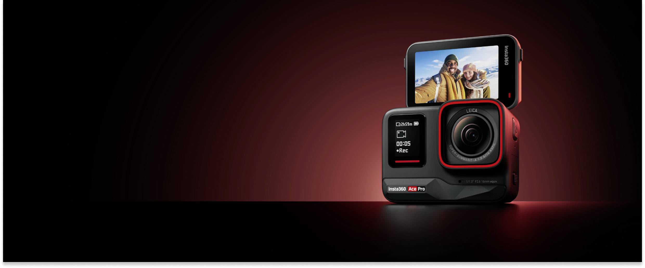A black action camera with a display shows a selfie photo of two people. The background is dimly lit in dark red.
