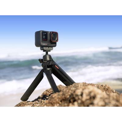 Camera on a tripod on a sandy beach with sea and sky in the background. Ideal for beach photography.