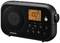 Black portable radio with illuminated display, showing 'FM 100.7' and '12:00'. Buttons for settings and volume on the front panel.