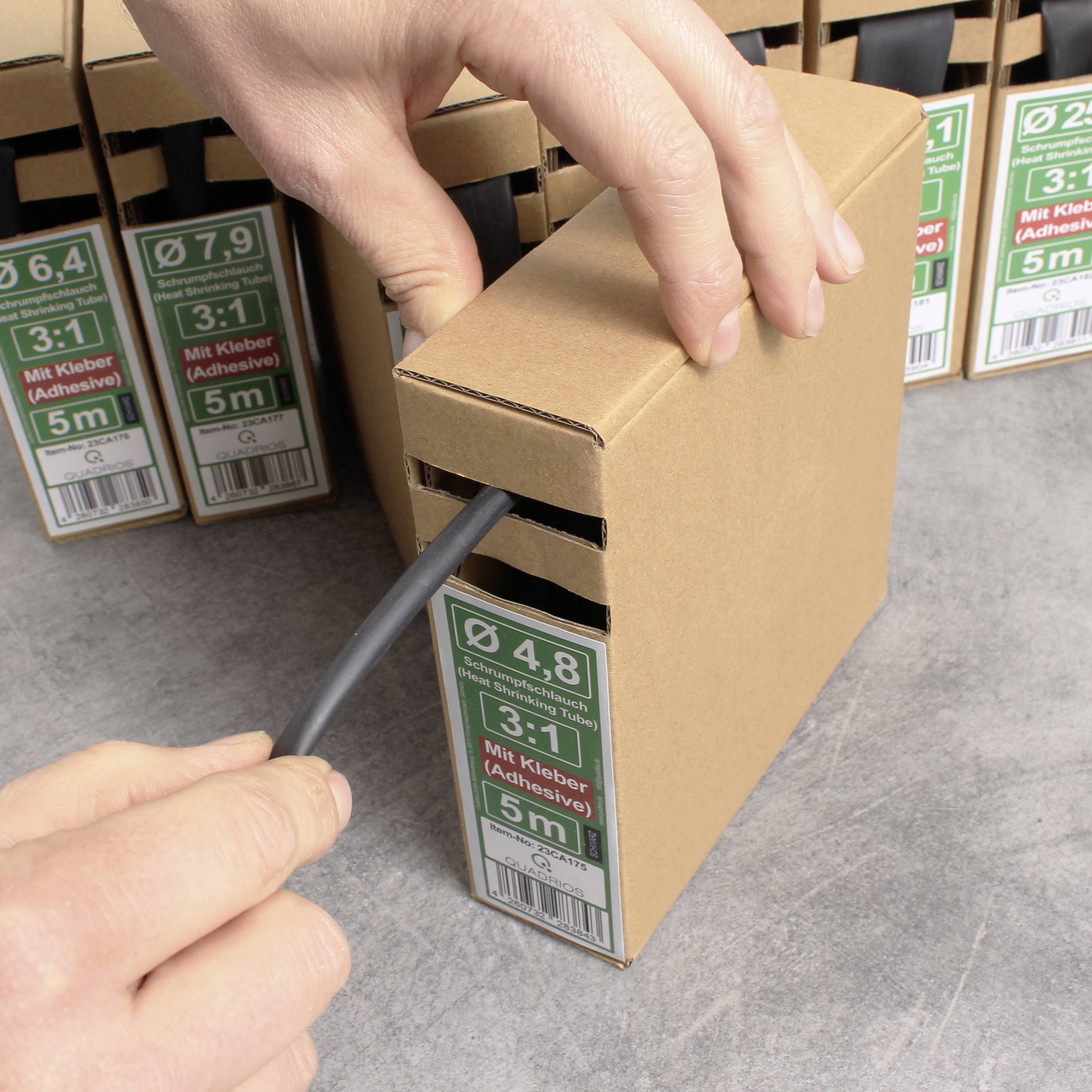 A hand pulls out a black cable from a brown package labelled '4.8 mm diameter, 3:1, With Adhesive, 5m'.