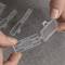 A hand is holding a small, transparent label marked '4020', which is being inserted into a larger, similar label.