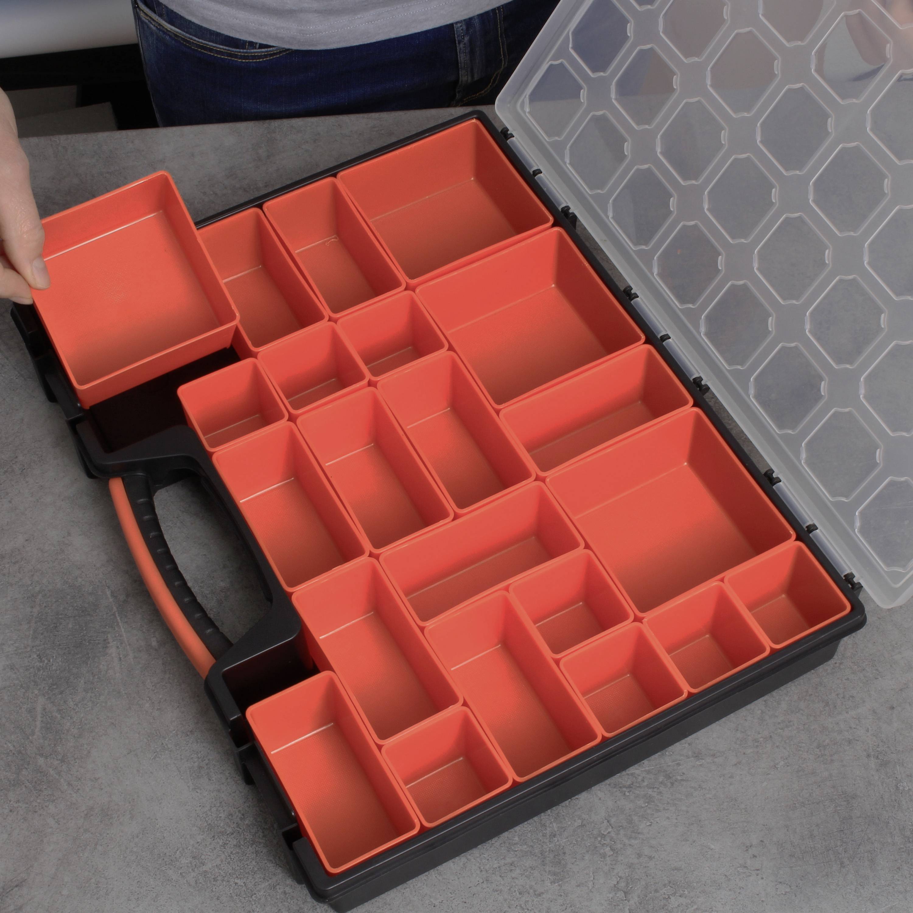 An open toolbox with multiple orange-red drawers of various sizes. A hand is holding a removable container.