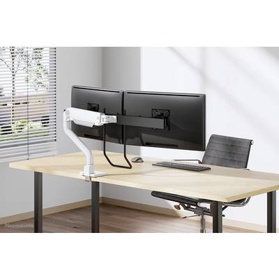 Two large monitors mounted on a dual-arm mount, positioned on a modern desk with a keyboard and ergonomic chair in the office.