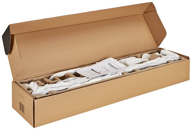 A long, opened cardboard box contains a packaged product. An instruction leaflet lies on top.