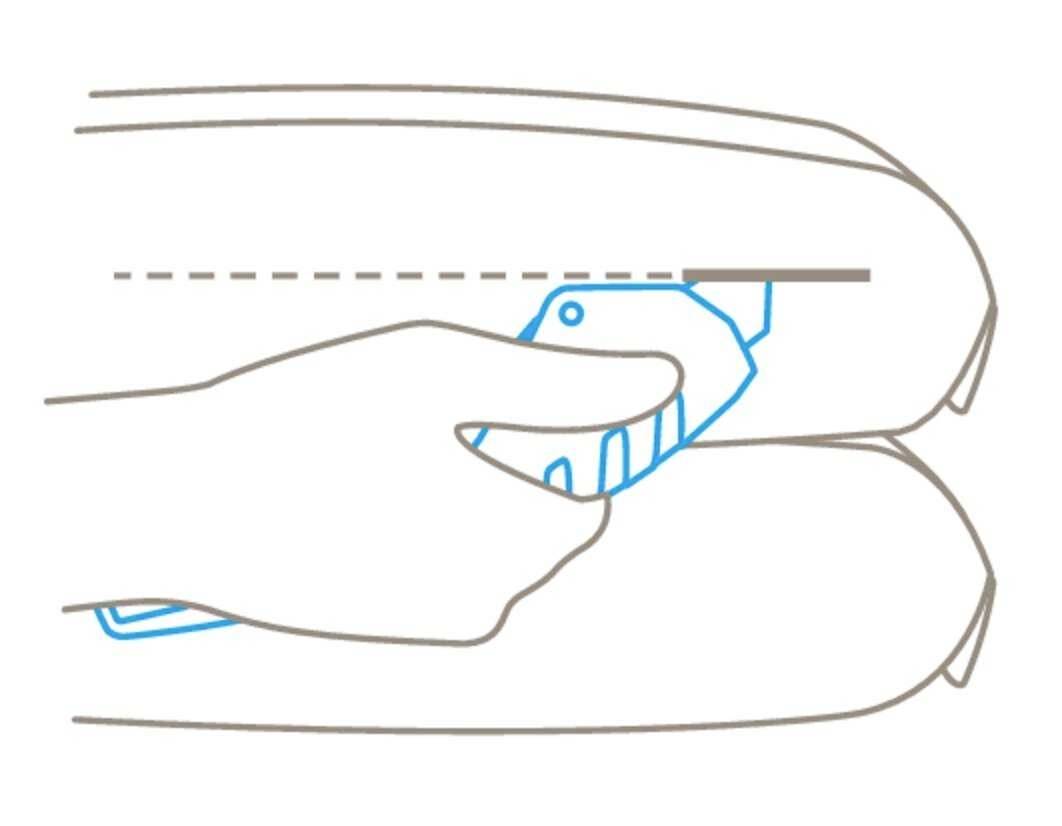 A hand holds a knife and cuts through a packaging box along a dotted line.