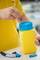 A person places a razor blade in a yellow disposal container with a blue lid. A safety box for sharp objects.