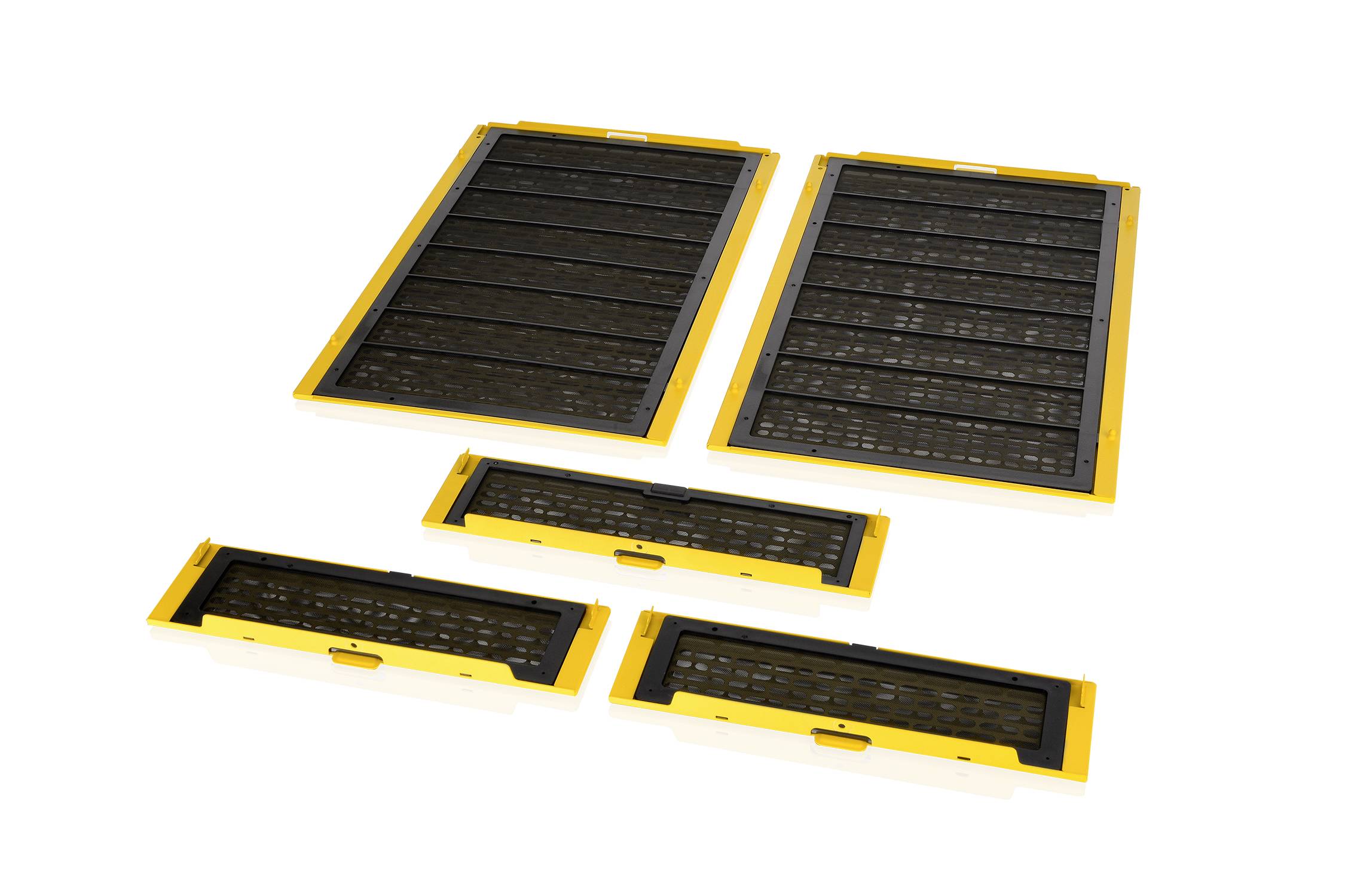 Five yellow and black plastic frames of varying sizes are lying on a white surface. They appear to be components of a ventilation system.