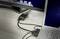 'Laptop connected to desktop monitor. Multiple cables lead to an adapter enabling the connection. Workplace scene.'