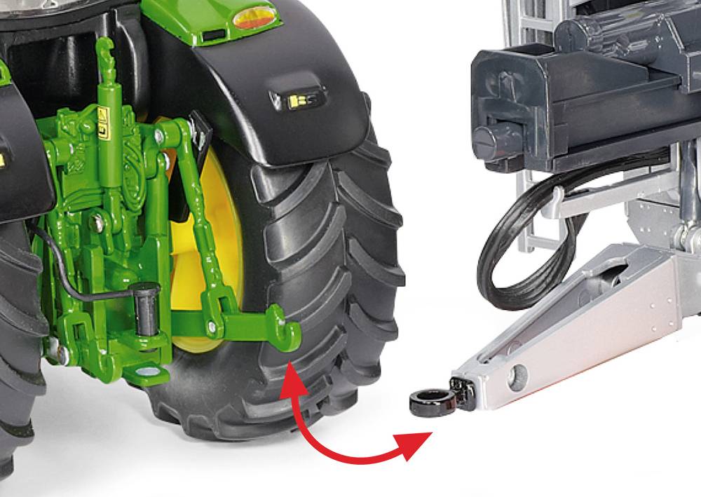 'Close-up of a tractor's rear wheel with a tow bar attached and an arrow indicating how to hitch a trailer.'