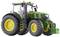 Green tractor with yellow wheels on a white background, suitable for agricultural work.