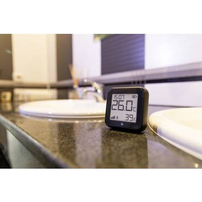 Digital thermometer shows 26.0°C and 39% humidity on a bathroom vanity.