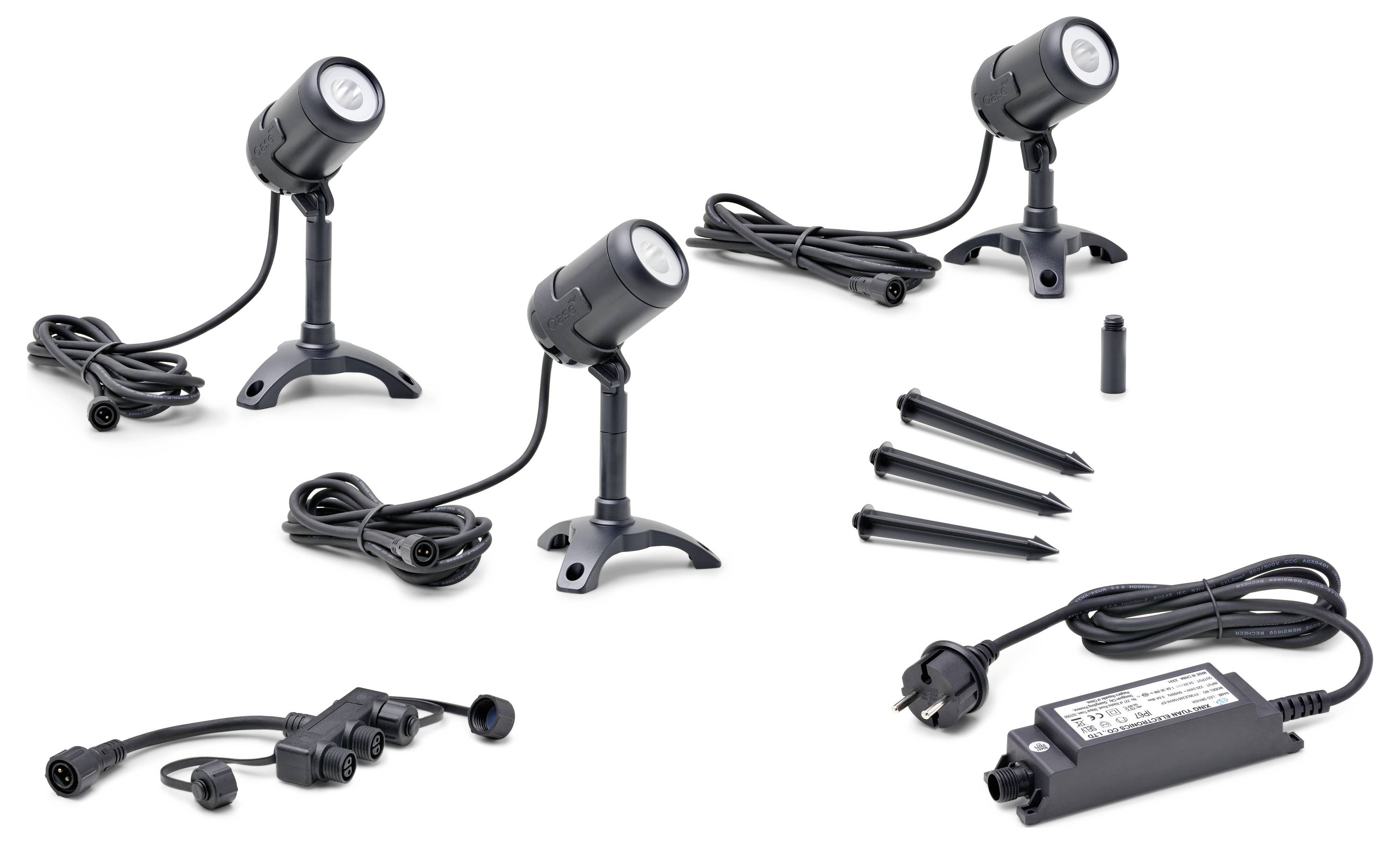 Outdoor lighting set including three spotlights with stands, spike mounts, power cables, and a transformer, shown in separate components.