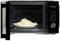 An open microwave with a plate of rice dish inside and a digital display showing the time 39:32.