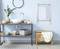 Modern bathroom with blue wall, washbasin on wooden shelf, towel rail, mirror, plants and decorative accessories.