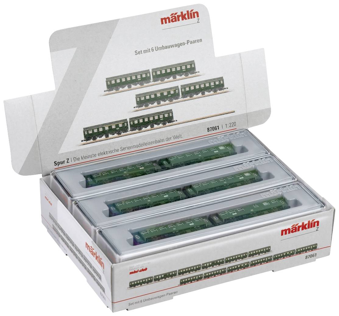 An opened Märklin model railway set in Z gauge shows six green electric locomotives in a white packaging.