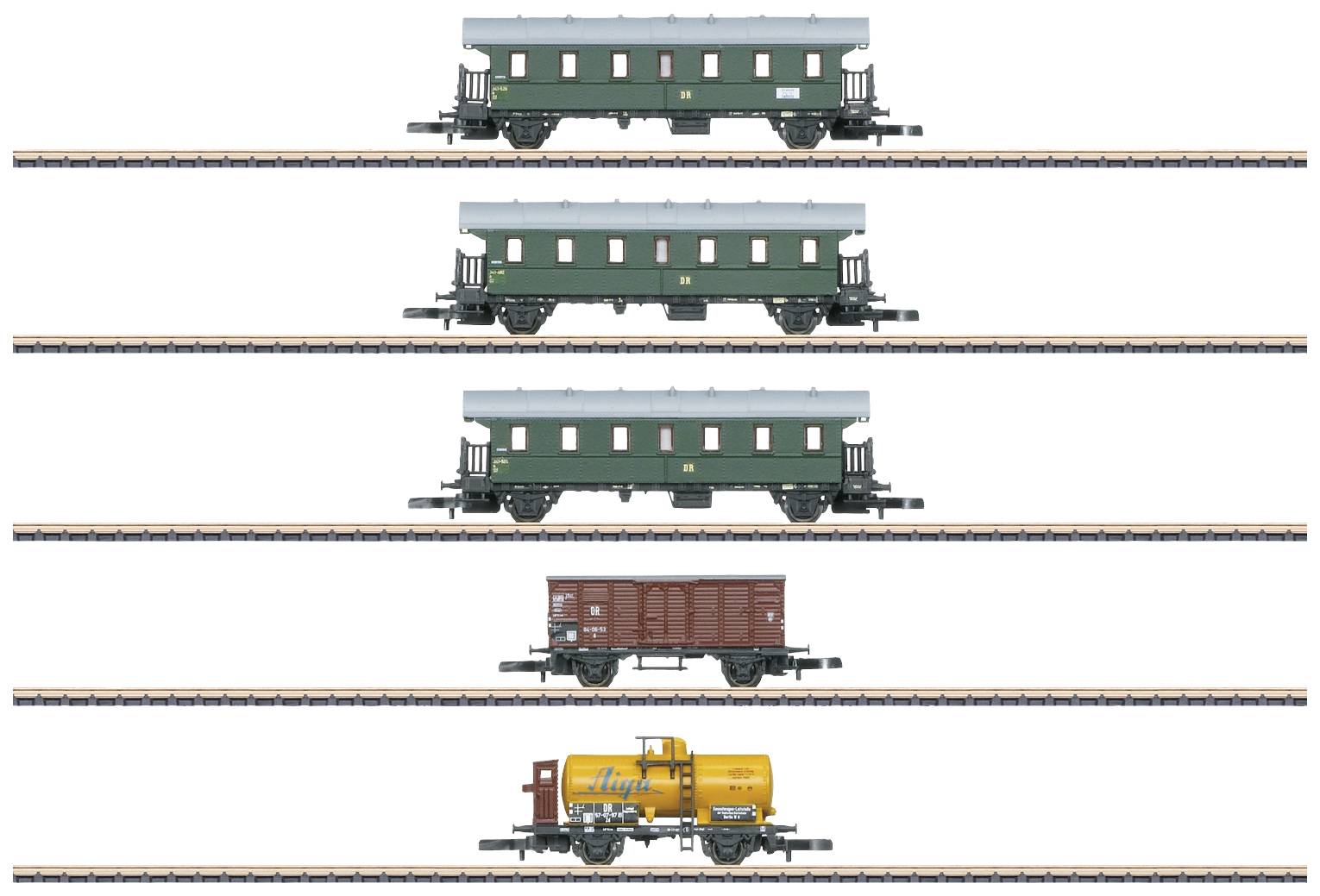 Four model railway carriages: two green passenger carriages, a brown goods wagon, a yellow tanker wagon with 'Aral' logo.