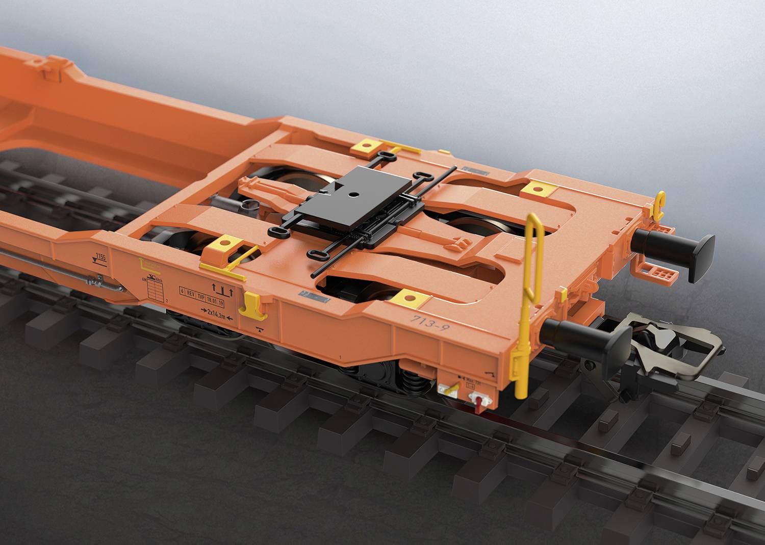 An orange railway freight wagon frame on tracks, showing a detailed view of the coupling and mounting system.