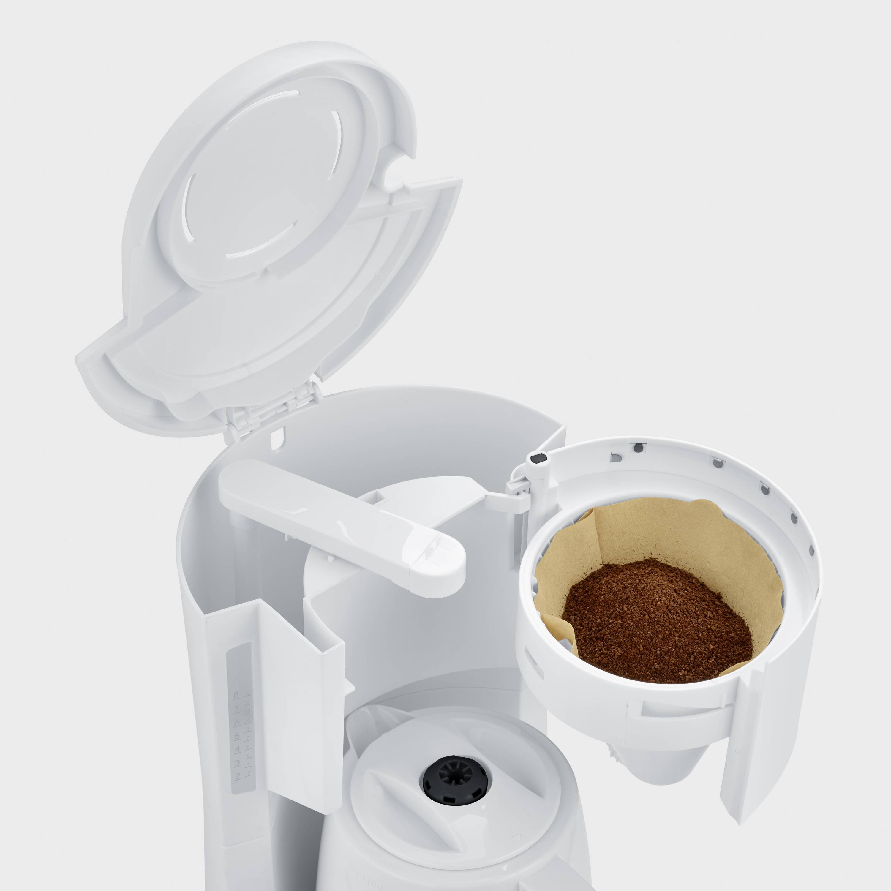 Coffee machine with an open filter holder, filled with ground coffee. The filter holder is removable.