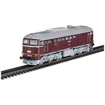A model locomotive in red and grey is travelling on a railway track. It has details such as windows and wheels in miniature scale.