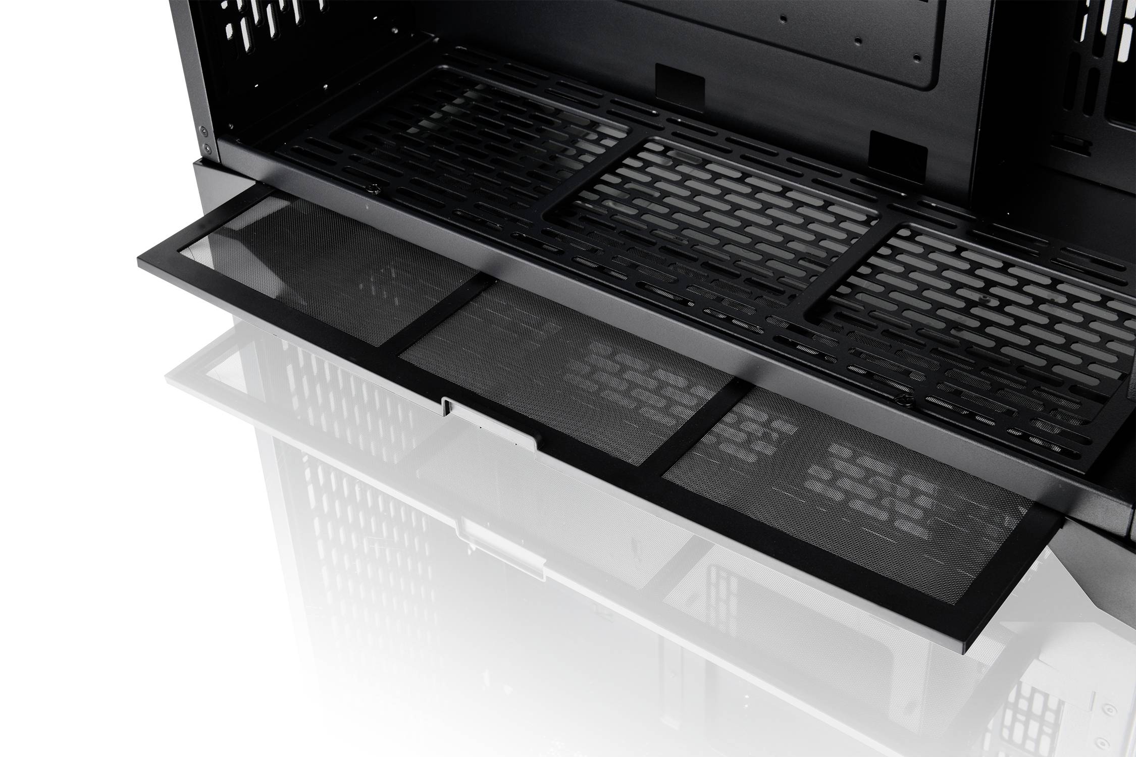 Dust filter at the bottom of an open computer case, ready for cleaning or replacement, revealing the interior of the case and air circulation details.