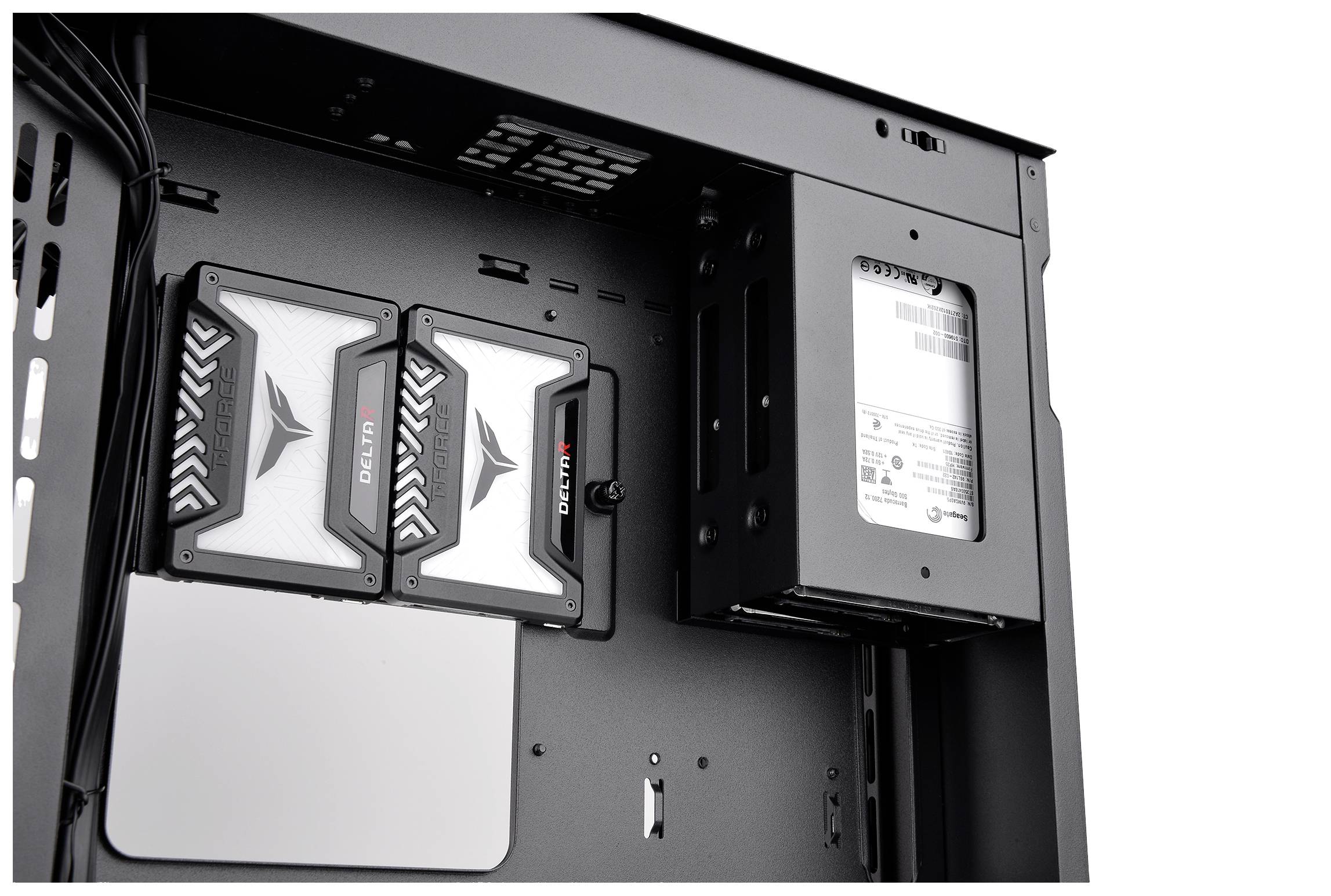 Interior view of a computer case with two mounted hard drives and an SSD. The environment is metallic and minimalist.