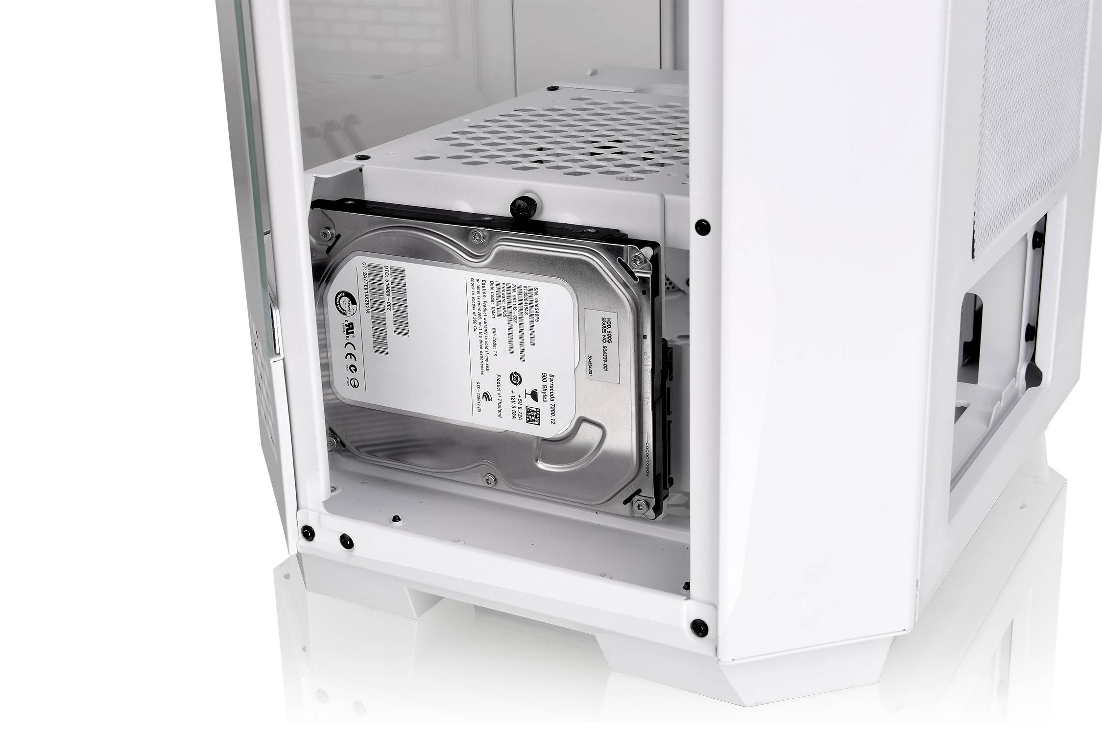 Hard drive installed in a computer case, surrounded by white components.