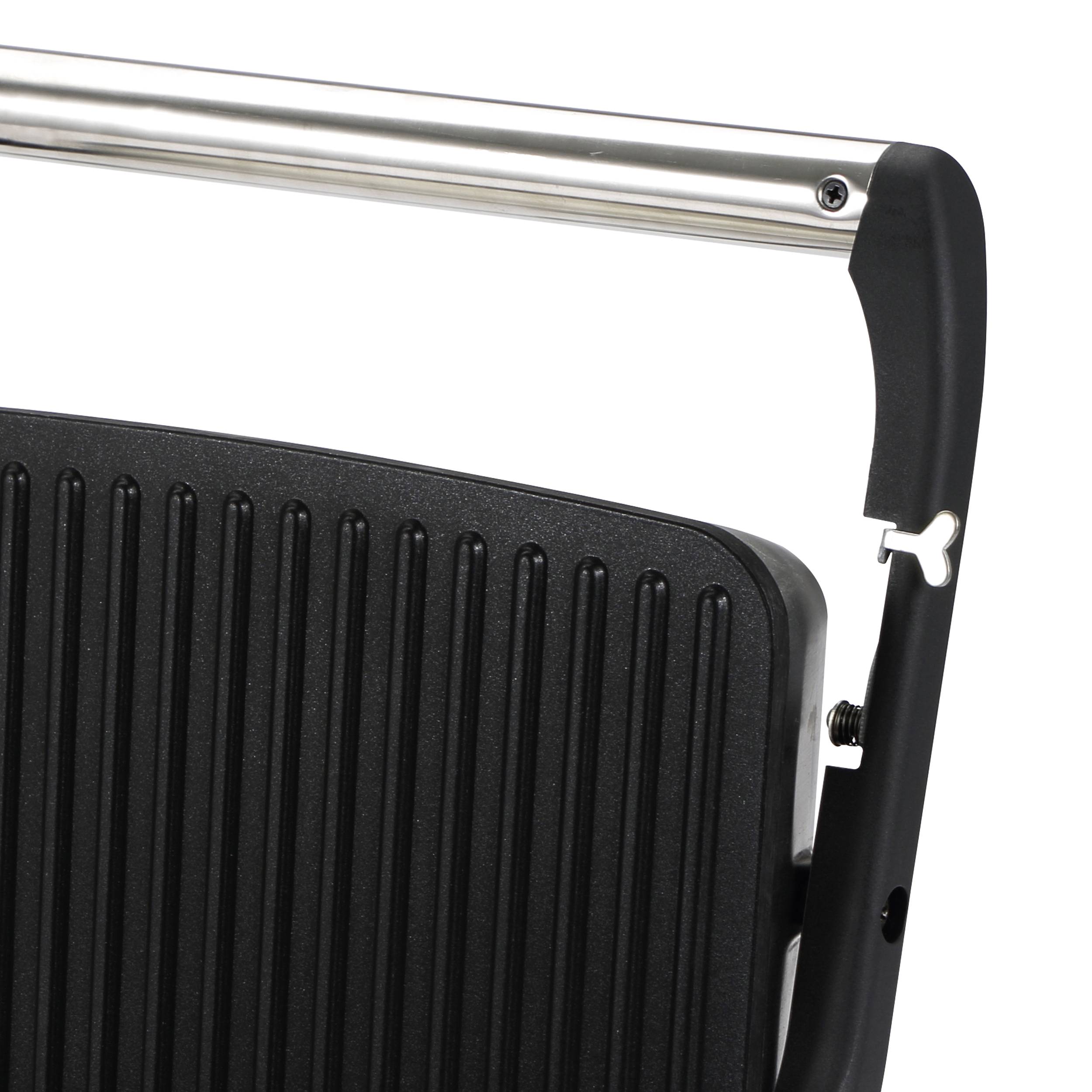 A black, ribbed sandwich grill appliance with a silver metal handle, partially visible, against a white background.