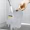 A hand holds a transparent water container under a tap. The container bears the yellow 'Kärcher' logo.