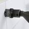 An electric cleaning brush cleans the grout between white tiles. The brush has black bristles.