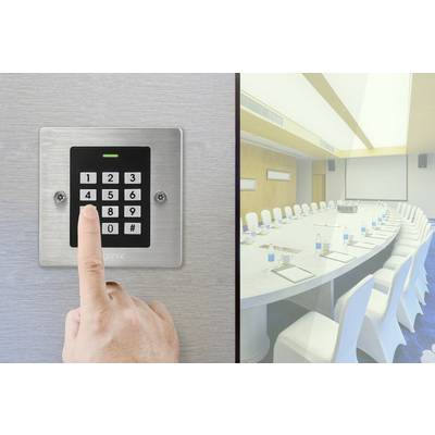A person is entering a code on a security keypad. To the right is a modern conference room with a large oval table.