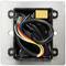 An open electrical wall socket with multiple coloured wires and a small yellow component mounted on a metal plate.