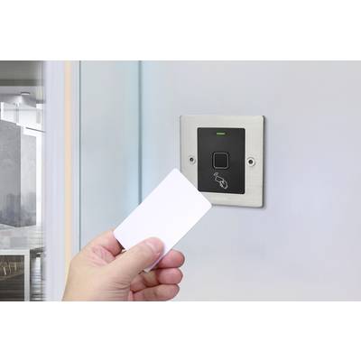 A person holds an access card in front of an electronic door lock with a green light, indicating a successful activation.