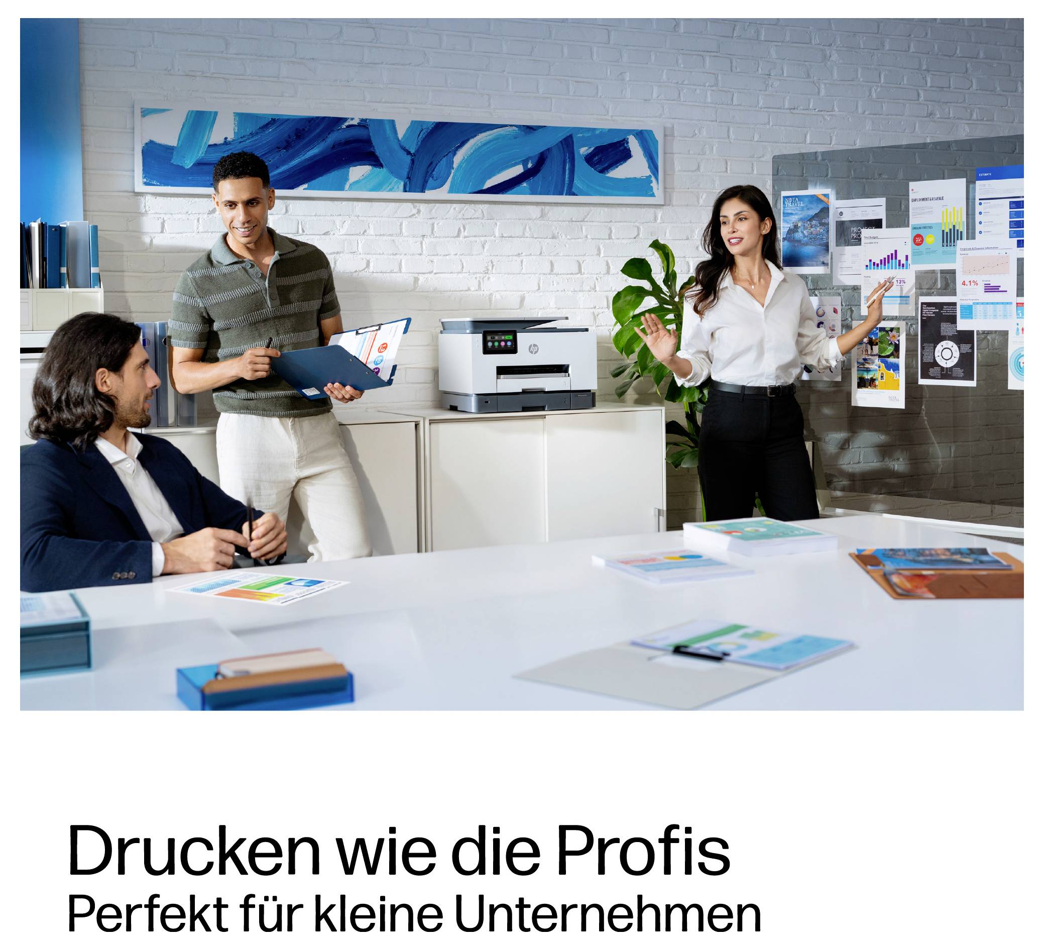 Three coworkers discuss charts in an office, with a printer on a cabinet; German text says 'Drucken wie die Profis' and 'Perfekt für kleine Unternehmen'.