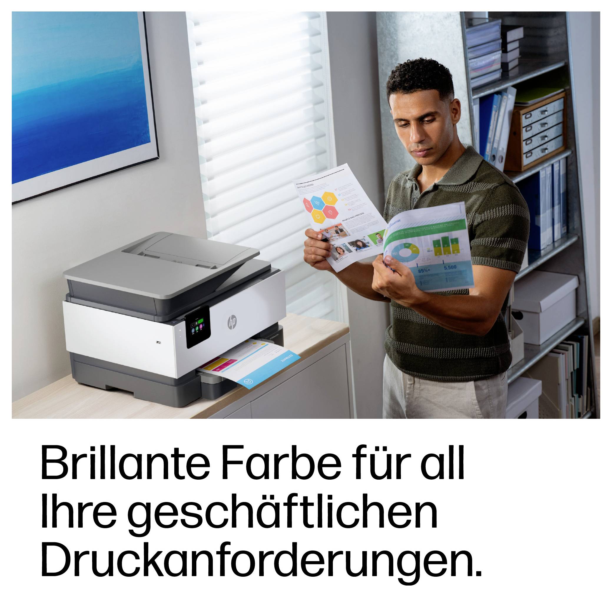 Man inspects a color print brochure beside a multifunction printer, illustrating business color printing; German text reads 'Brillante Farbe für all Ihre geschäftlichen Druckanforderungen.'<br>