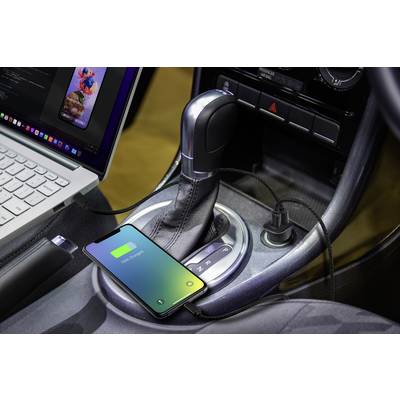 A smartphone is charging in the car, connected via a USB cable next to a laptop on the centre console.