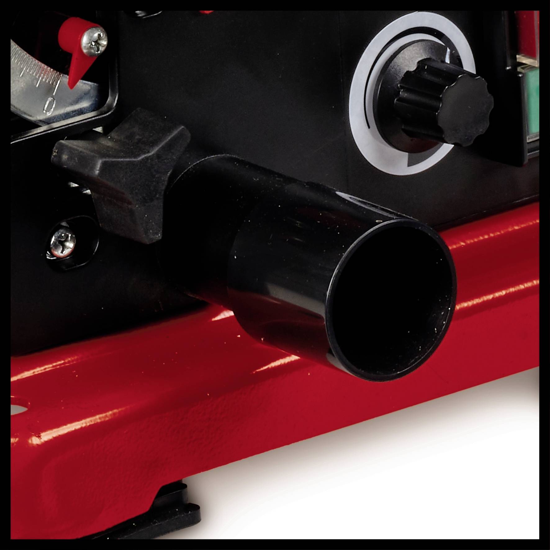 Close-up of a black nozzle on a machine with red details, next to a black rotary knob.