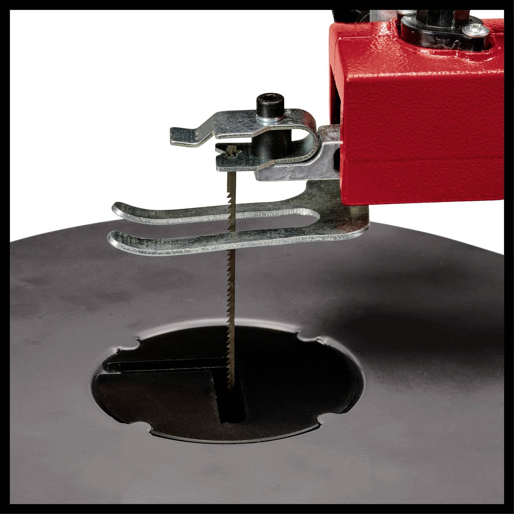 The close-up shows a scroll saw with a red casing on a table surface. The saw blade position is clearly visible.