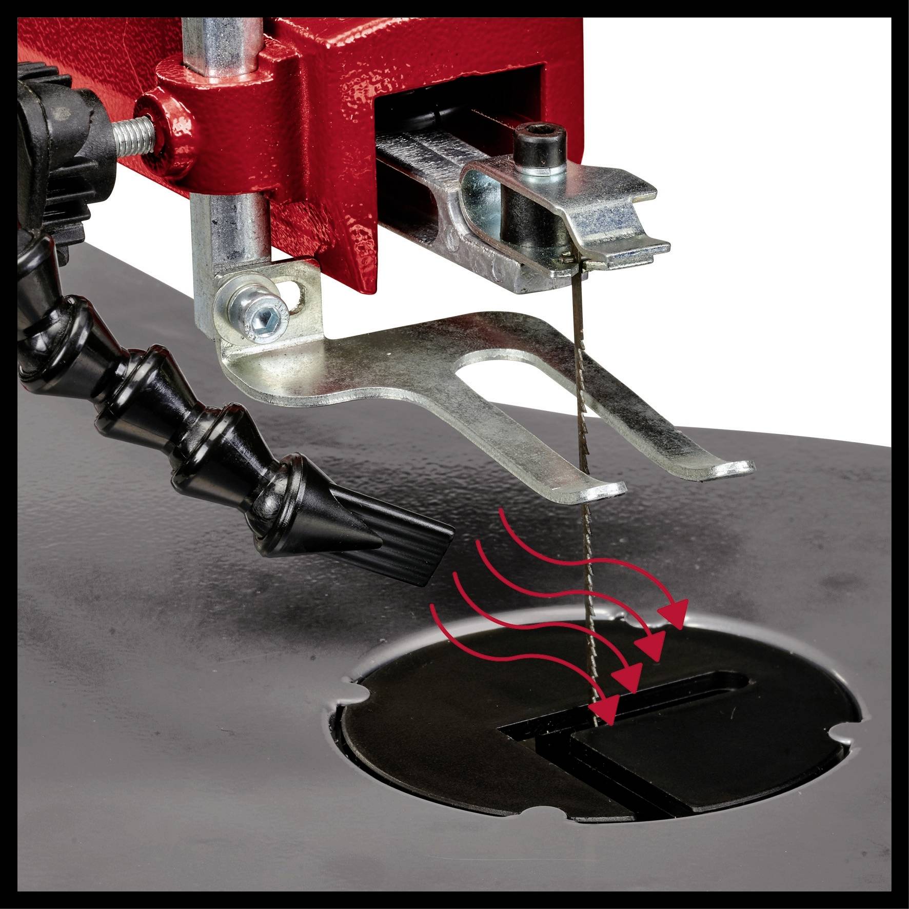 A jigsaw cuts wood; red casing, black table; saw blade moving vertically through round table slot.