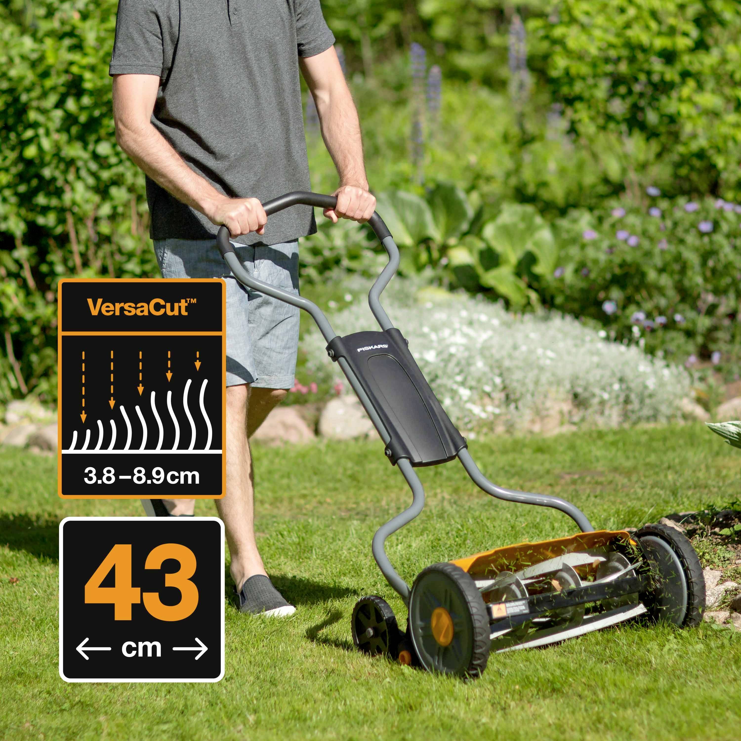 A person is using a cylinder mower in the garden. On the side it reads 'VersaCut' with adjustable cutting height of 3.8-8.9 cm and a width of 43 cm.