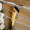 An orange metal handle leaning against a wooden beam, resting on a pile of logs.
