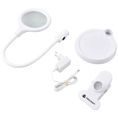 A small, round LED magnifying glass with a flexible arm, base, power adapter, and a holding clip featuring the 'Toolcraft' logo.