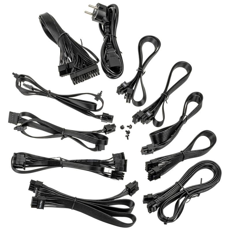 Several black computer power cables and plugs with various connections are lying unsorted on a white surface.