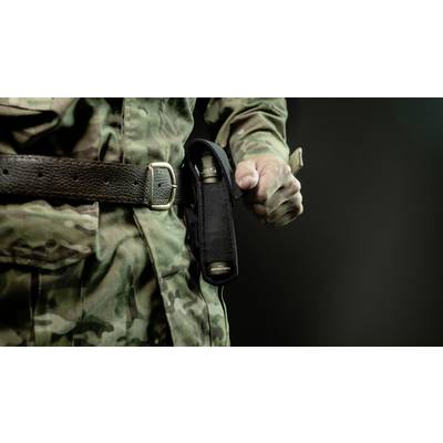 A person in camouflage uniform draws a pen from a holder on their belt. The background is dark, with the focus on the action.